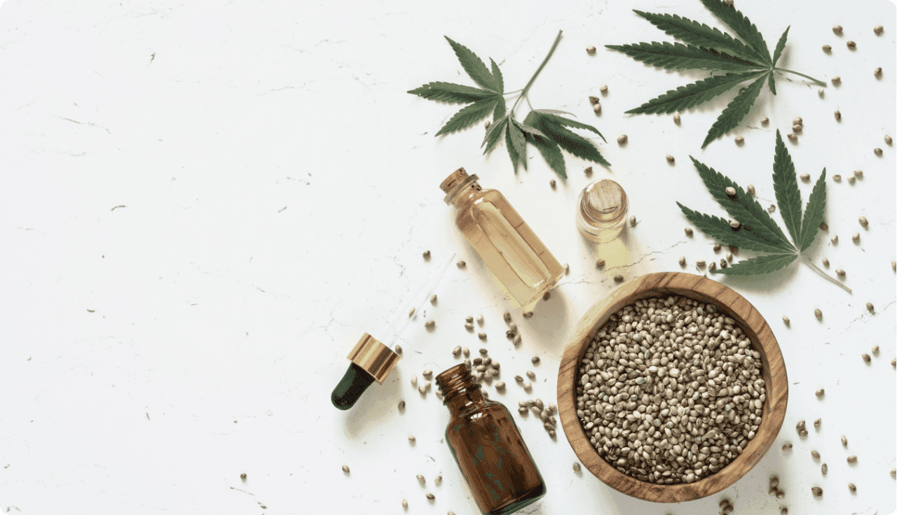 Cannabisblätter und kleine Fläschchen mit Öl